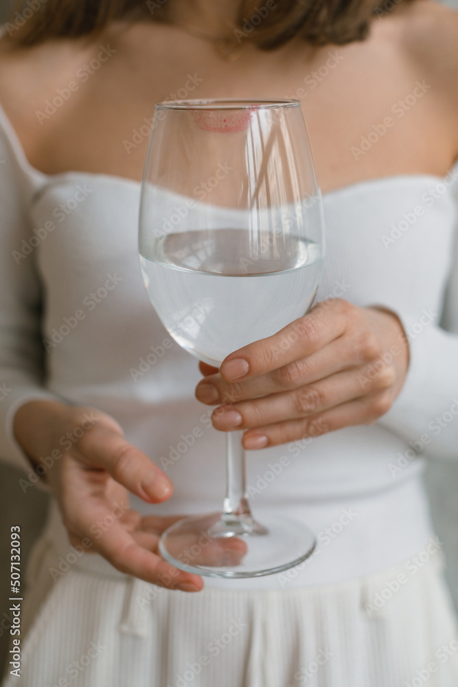 Aesthetic shot of woman in white clothes holding glass of water. Aesthetic shot of woman in white clothes holding glass of water.