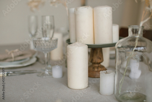 Close up of stylish table setting in beige colors. Natural materials, home decorations. Aesthetics.