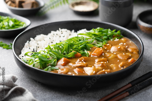 Japanese curry with rice in a black ceramic plate, selective focus photo