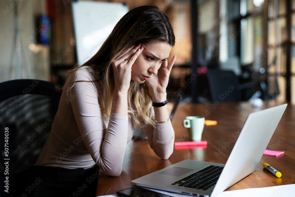 Portrait of tired businesswoman. Sad exhausted woman working on laptop in the office.. Portrait of tired businesswoman. Sad exhausted woman working on laptop in the office..