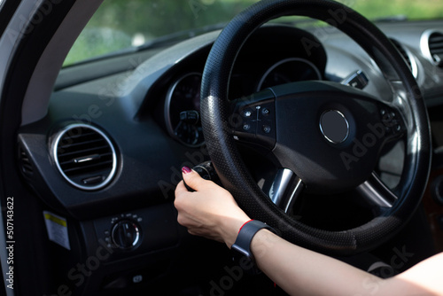 Woman's hands on the steering wheel of the car.