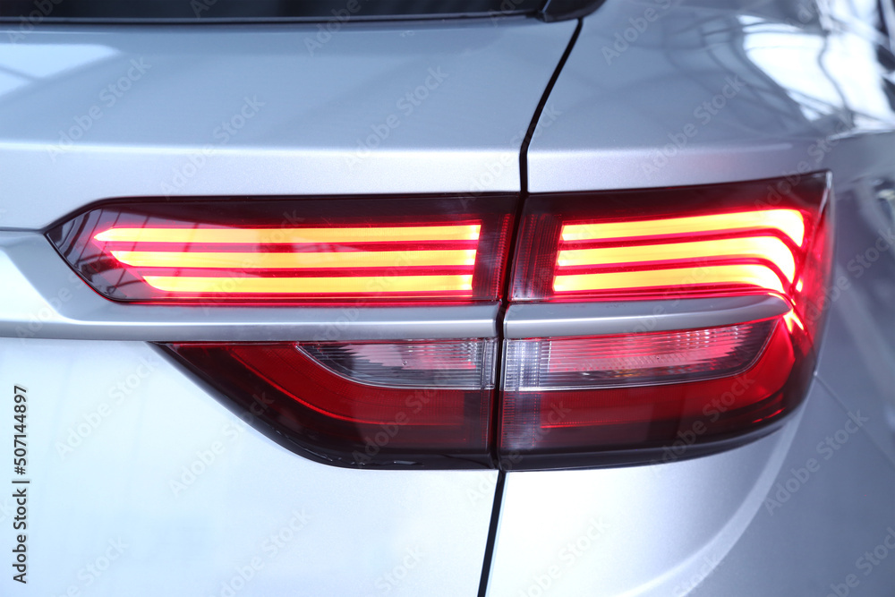 The back of a white expensive crossover car: Close up detail on one of the LED red tail light modern crossover car. Exterior detail automobile. Mock up for the advertising industry. New car concept.