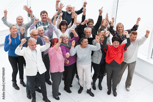 group of elderly friends raised their hands up and celebrate suc