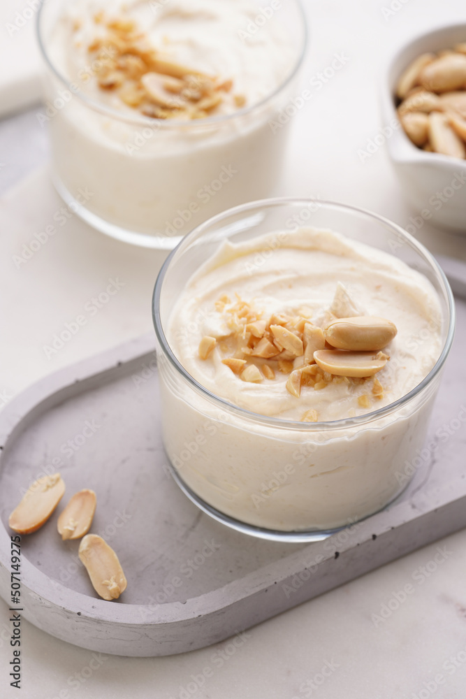 Creamy dairy yoghurt dessert with mascarpone, cream cheese and peanut butter in glasses on concrete tray Creamy dairy yoghurt dessert with mascarpone, cream cheese and peanut butter in glasses on concrete tray