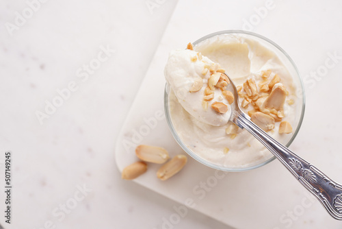 Creamy dairy yoghurt dessert with mascarpone, cream cheese and peanut butter in glasses on marble tray