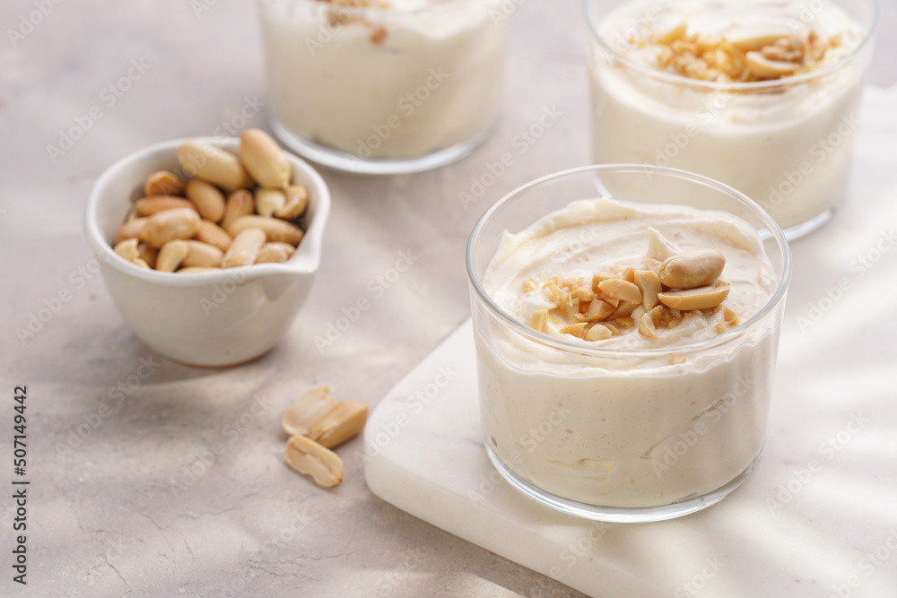 Creamy dairy yoghurt dessert with mascarpone, cream cheese and peanut butter in glasses on marble tray Creamy dairy yoghurt dessert with mascarpone, cream cheese and peanut butter in glasses on marble tray