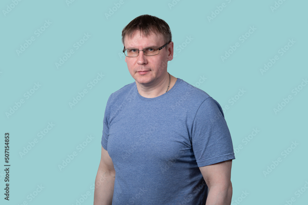 Portrait of a man with glasses and a blue T-shirt on a blue background. Portrait of a man with glasses and a blue T-shirt on a blue background.