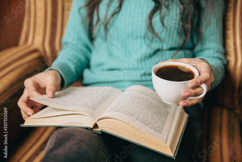 woman reading book and drinking coffee