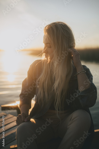 dziewczyna na tle zachodzącego słońca nad jeziorem