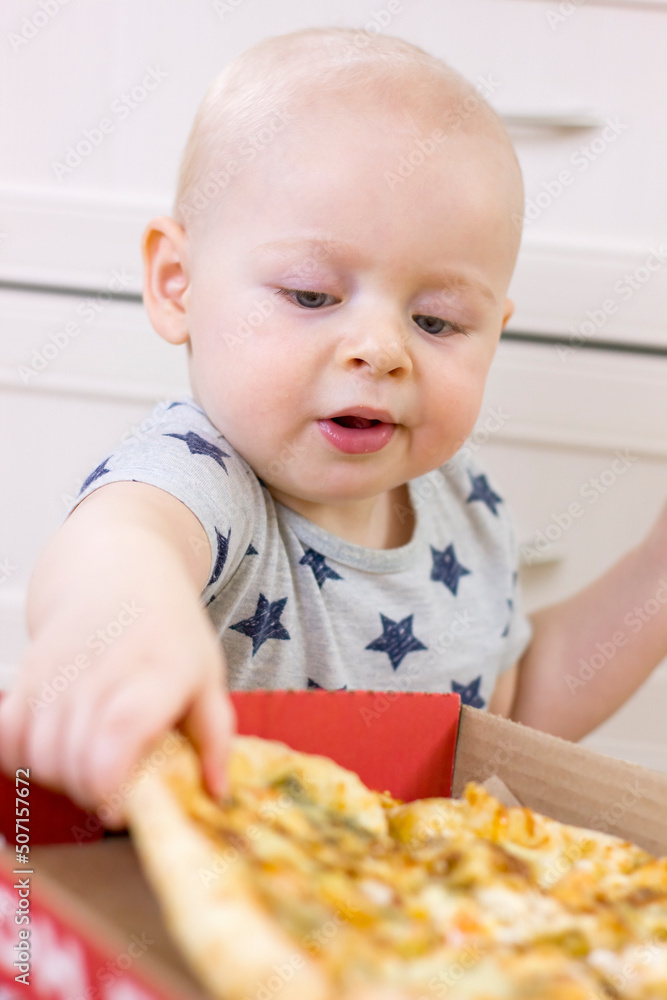 Cute little kid boy taking a slice of pizza. Cute little kid boy taking a slice of pizza.