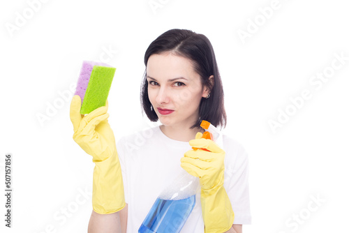 woman brunette cleaner in yellow gloves holding dishwashing sponge and window cleaner, white studio background