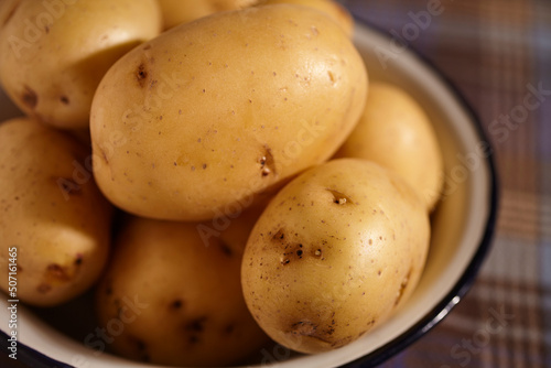 Raw, whole, yukon gold, potatoes in a bowl