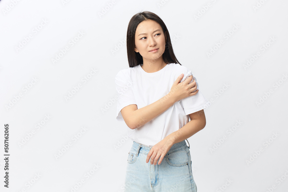 Suffering from neuralgia after sleeping in the wrong position tanned beautiful young Asian woman touching painful shoulder posing isolated on white background. Injuries Poor health Illness concept Suffering from neuralgia after sleeping in the wrong position tanned beautiful young Asian woman touching painful shoulder posing isolated on white background. Injuries Poor health Illness concept