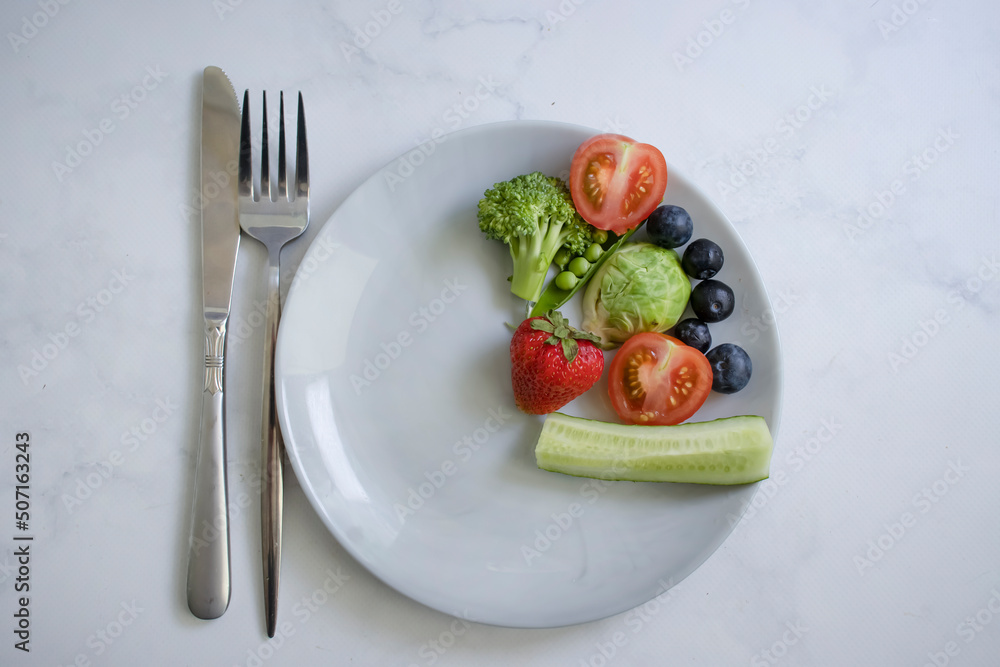 Vegetables and fruits on a plate on a light background