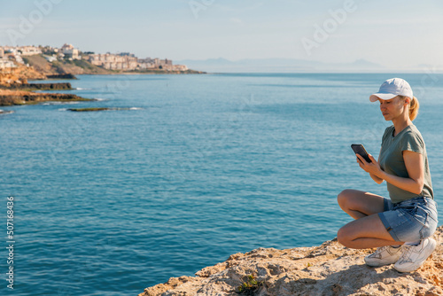 Young woman on vacation takes a selfie by the sea - lifestyle, tourism and sharing moments concept © Enigma