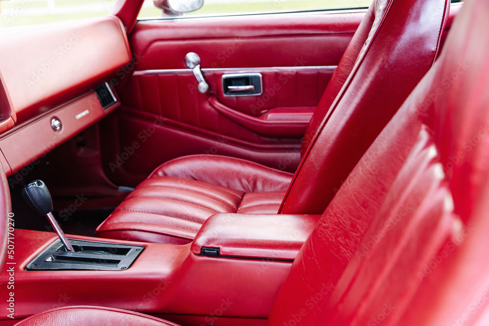 interior is made of red leather of old powerful classic American car