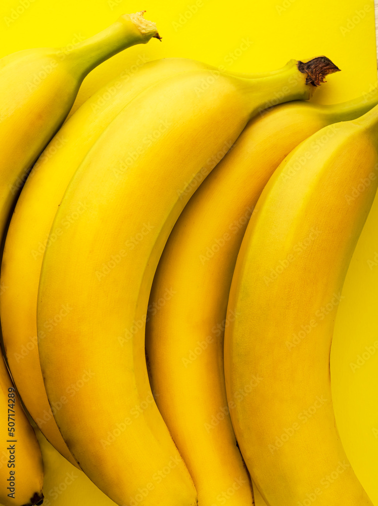 A bunch of bananas is on the table. Bananas isolated on yellow background
