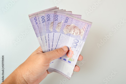 Hand holding stack of ringgit Malaysia money banknotes photo