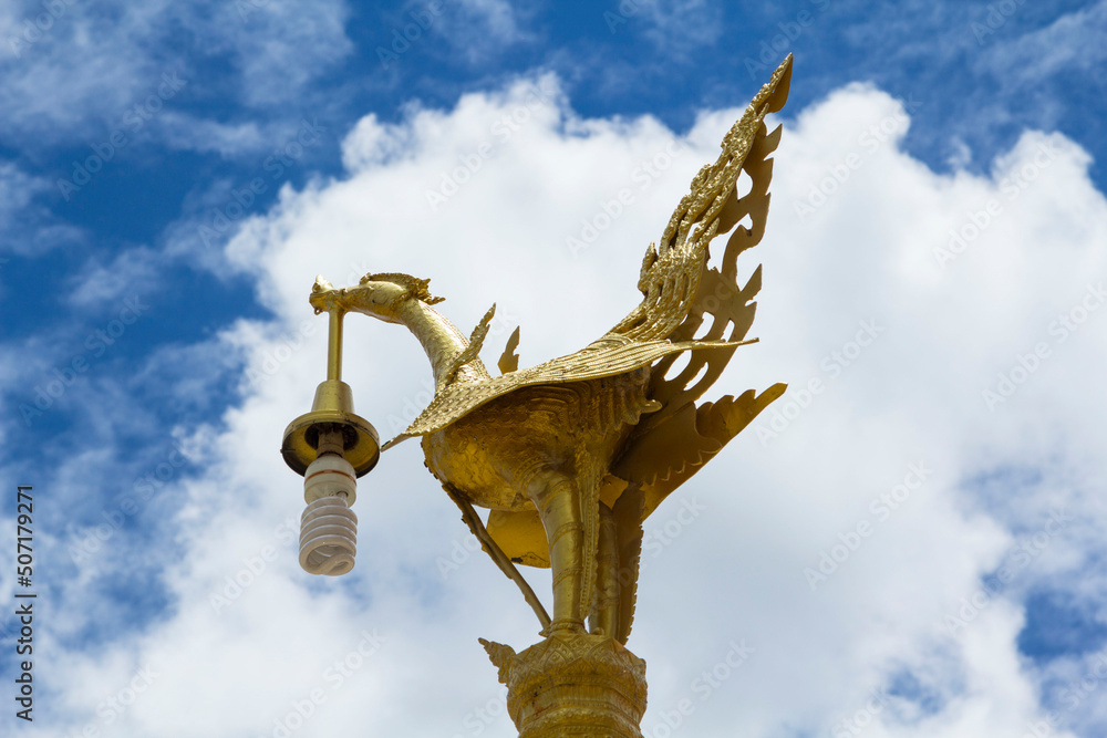 Night lamp - a brass casting in the shape of a swan and a graceful and beautiful animal in Thai literature against a blue sky background. Night lamp - a brass casting in the shape of a swan and a graceful and beautiful animal in Thai literature against a blue sky background.