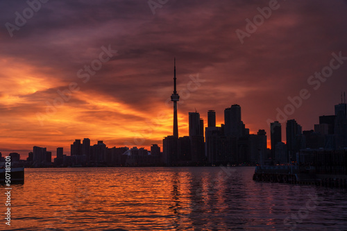 Summer sunset view from Toronto Islands across the Inner Harbour of the Lake Ontario on Downtown Toronto skyline with skyscrapers under a magnificent sky
