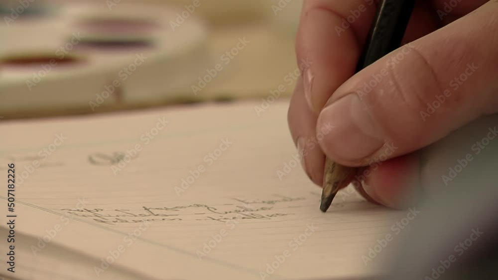 Primary School Student Writing on Notebook using a Pencil. Close Up. Primary School Student Writing on Notebook using a Pencil. Close Up.