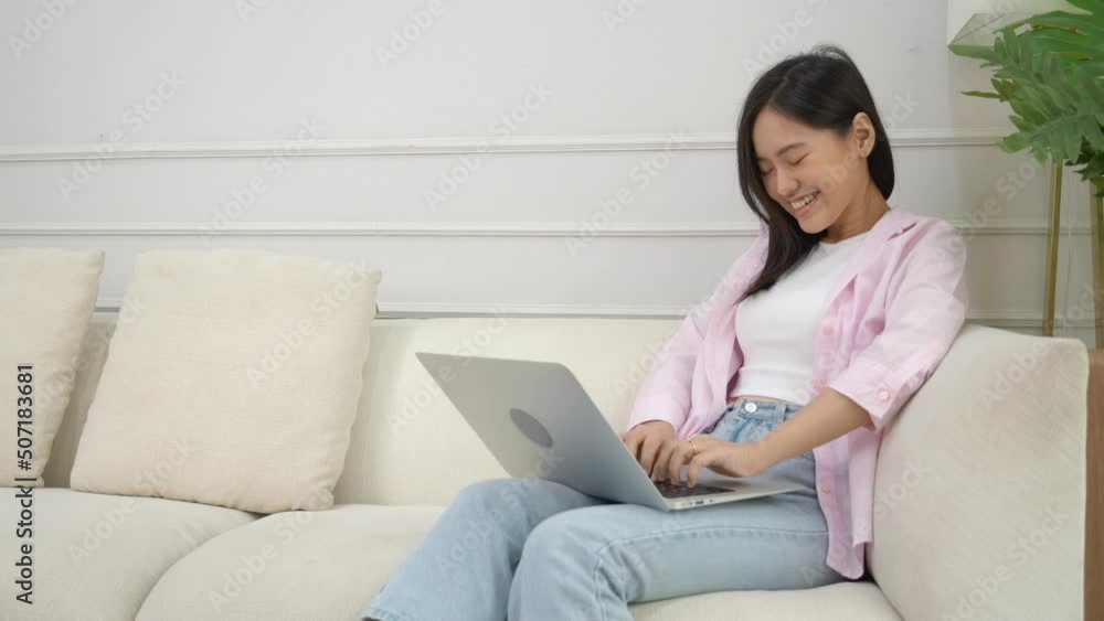 Young asian business woman work from home with laptop computer online to internet on sofa in living room, freelance girl using notebook sitting on couch with comfort and relax, lifestyles concept. Young asian business woman work from home with laptop computer online to internet on sofa in living room, freelance girl using notebook sitting on couch with comfort and relax, lifestyles concept.