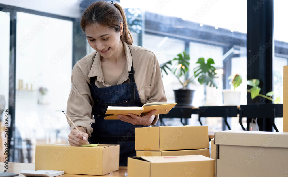 Asian woman writing clipboard, home delivery, SME e-commerce concept , Home online business , Delivery concept Asian woman writing clipboard, home delivery, SME e-commerce concept , Home online business , Delivery concept