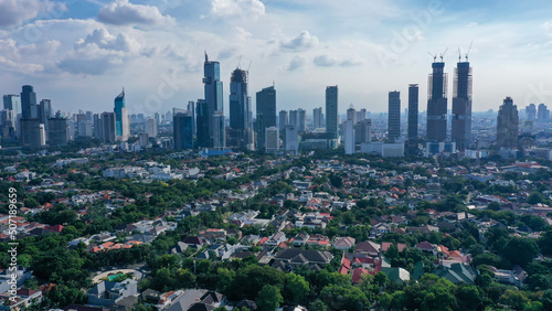 Dramatic sky over Jakarta downtown skyline where modern skyscrapers contrasts with poor residential district in Indonesia capital city