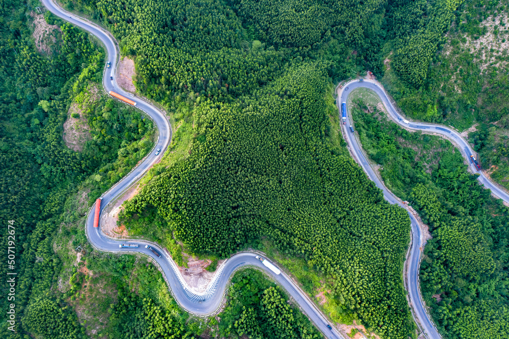 Transporting wind turbine propeller through curvy jungle road. Clean alternative energy to reduce global warming and climate change for sustainable growth. Transporting wind turbine propeller through curvy jungle road. Clean alternative energy to reduce global warming and climate change for sustainable growth.