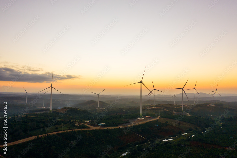 Wind turbines on beautiful sunny mountain and forest landscape. Green ecological power energy generation. Wind farm eco field to reduce global warming and climate change and pollution Wind turbines on beautiful sunny mountain and forest landscape. Green ecological power energy generation. Wind farm eco field to reduce global warming and climate change and pollution