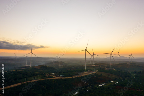 Wind turbines on beautiful sunny mountain and forest landscape. Green ecological power energy generation. Wind farm eco field to reduce global warming and climate change and pollution