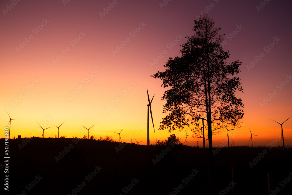 Obraz premium Wind turbines power plant at sunset are alternative electricity, the concept of sustainable resources. Green energy concept to reduce global warming and climate change and pollution