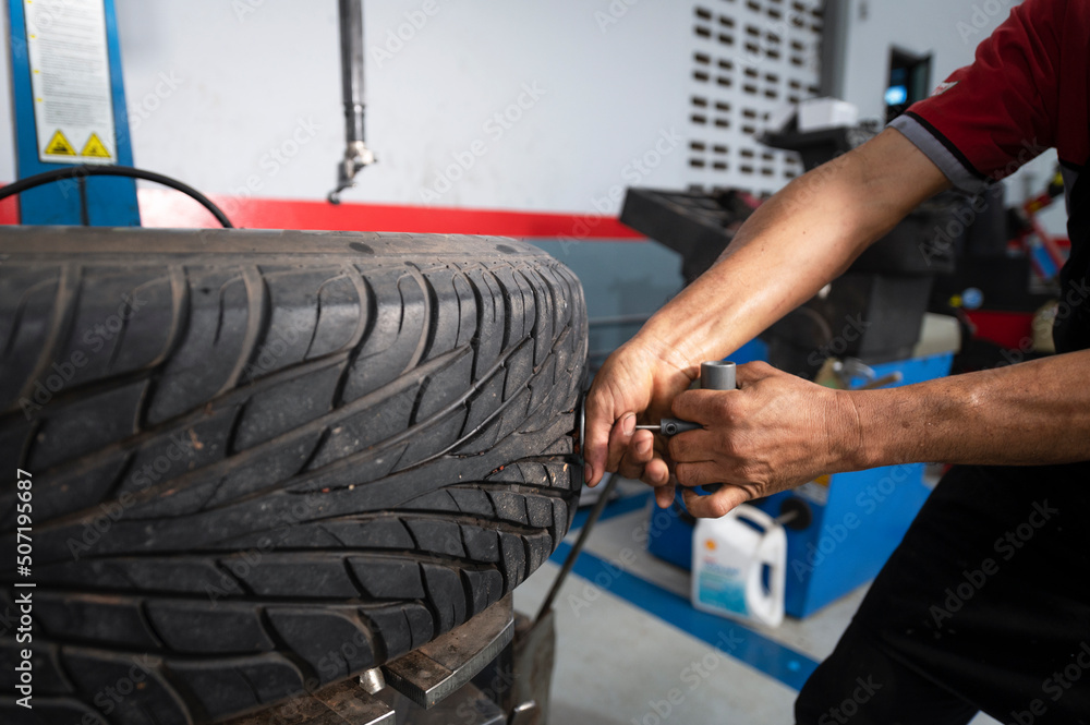 A set of workers remove the tire from the rim with a tire-removing machine device,Mechanic repairing tire A set of workers remove the tire from the rim with a tire-removing machine device,Mechanic repairing tire