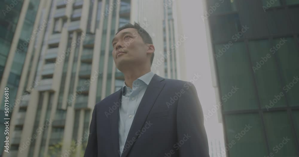 Business Male Outdoors on Street looking at Urban Skyline Business Male Outdoors on Street looking at Urban Skyline