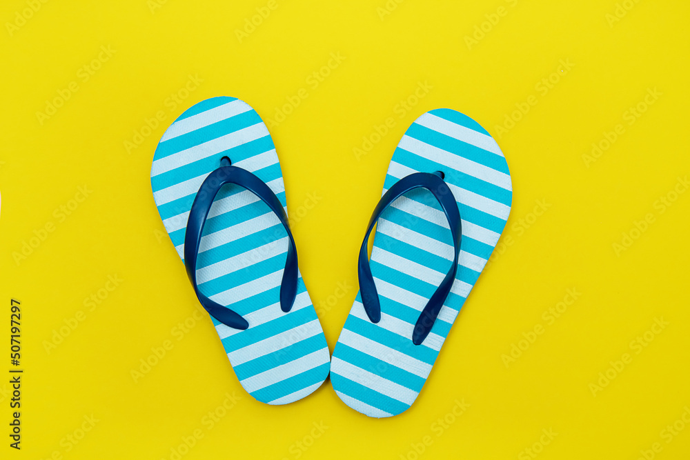 children's striped beach flip-flops on a yellow background children's striped beach flip-flops on a yellow background