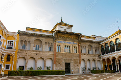 Buildings of Alcazar palace in Sevilla. With beautiful formal public garden inside Alcazar Seville palace in summertime in Andalusia