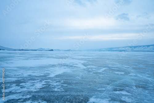 Baikal Lake. Unusual winter landscape. White layered bubbles in transparent ice