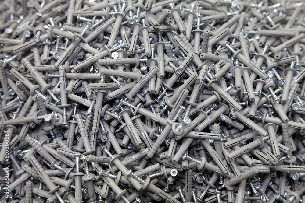 A lot of new nailing plugs concrete nails. Construction fasteners. Technical background texture. A lot of new nailing plugs concrete nails. Construction fasteners. Technical background texture.