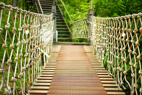 The wooden suspension bridge is a walkway in the middle of the forest.