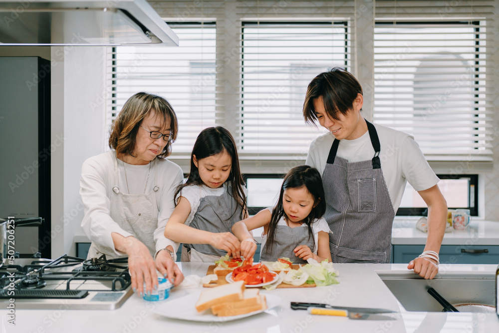 キッチンで一緒に食事の準備をしている家族 キッチンで一緒に食事の準備をしている家族