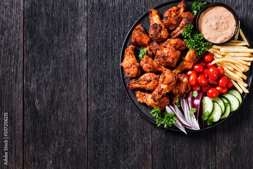 фотографія roast chicken wings with french fries and veggies