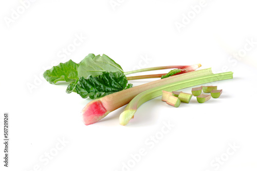 Red and green rhubarb stalks with leaves, rhubarb pieces isolated on a white background. Fresh useful plant from the garden.