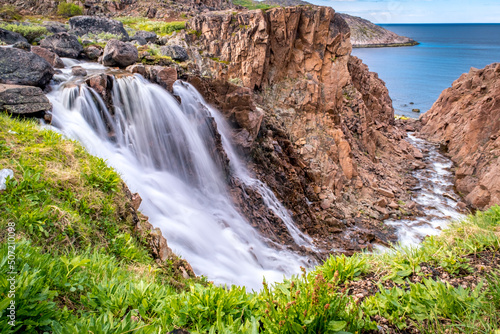Summer polar landscape with waterfall in Teriberka. Kola Peninsula of the Barents Sea. The nature of the north of Russia photo