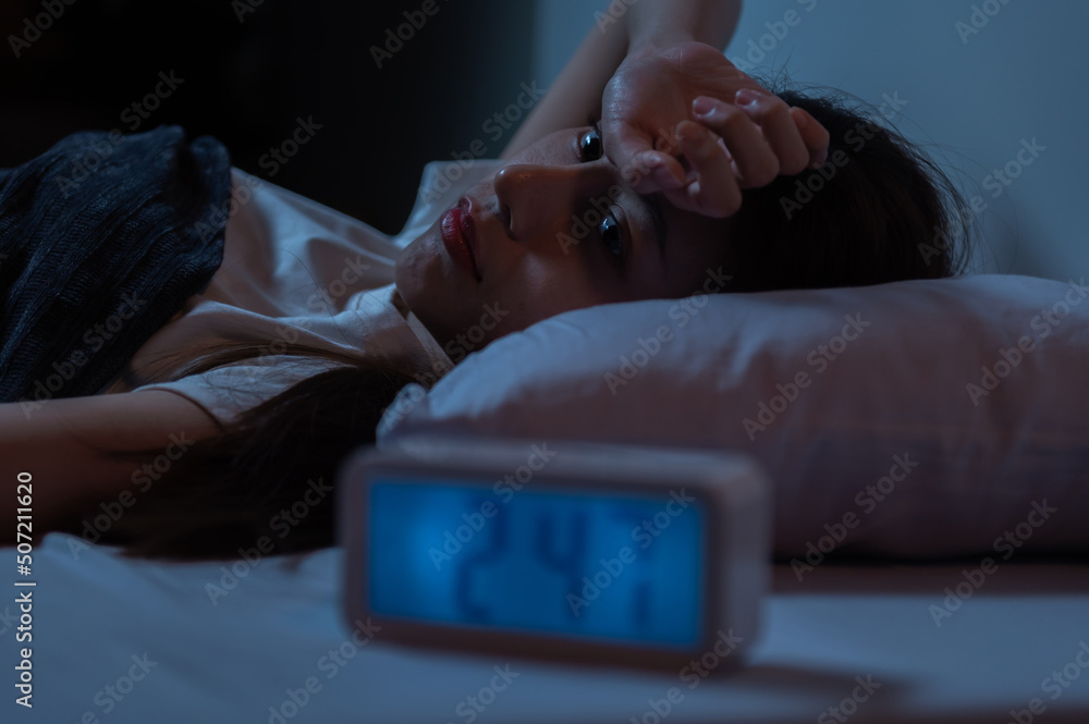 Young Asian woman suffer from insomnia can't sleep at night awaken from stress mental health problem or migraine. Young people health care psychiatry concept. - obrazy, fototapety, plakaty 