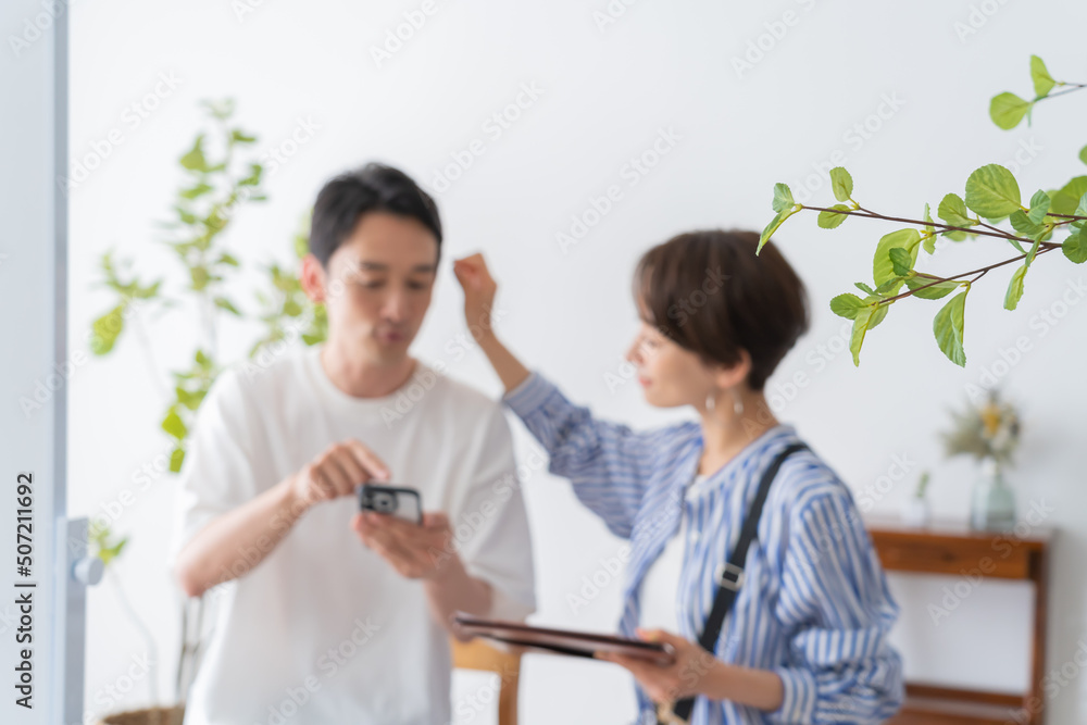 携帯を見せて希望を伝える男性客と女性美容師