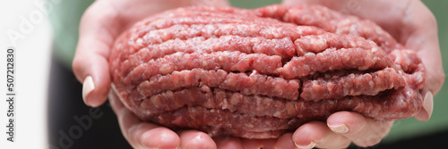 Female hands hold fresh minced meat, close-up