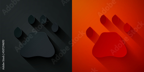 Paper cut Bear paw footprint icon isolated on black and red background. Paper art style. Vector