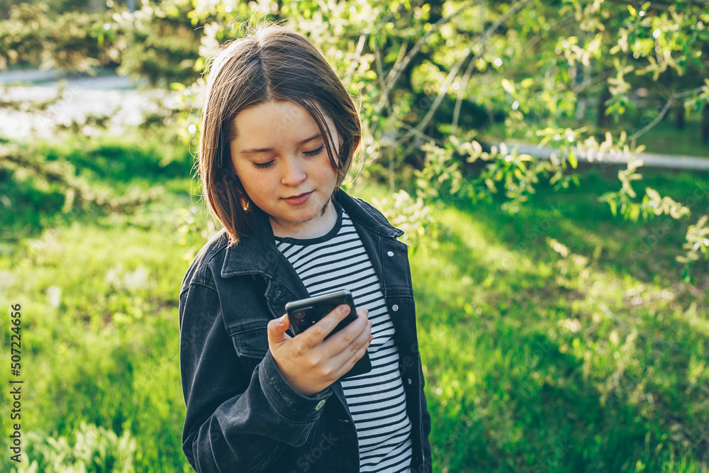 Preteen girl holding phone, using cell phone for chatting with friends ...