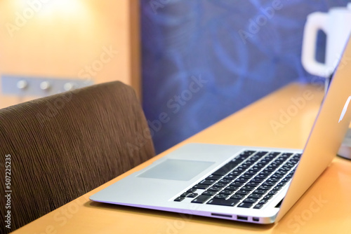 ホテルのデスクに置いたノートパソコン　テレワーク　出張　イメージ	