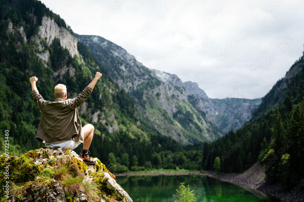 Active hiker hiking, enjoying the view, looking at mountain landscape Active hiker hiking, enjoying the view, looking at mountain landscape